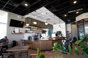 Interior of Armor Coffee with man sitting at desk and plant in bottom right corner