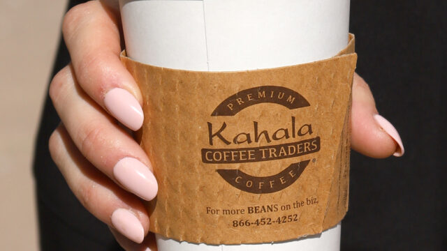 Hand holding Kahala Coffee Traders cup