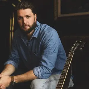 Musician Ben Coleman sitting next to his guitar