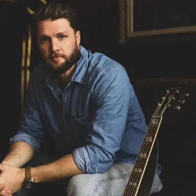Musician Ben Coleman sitting next to his guitar