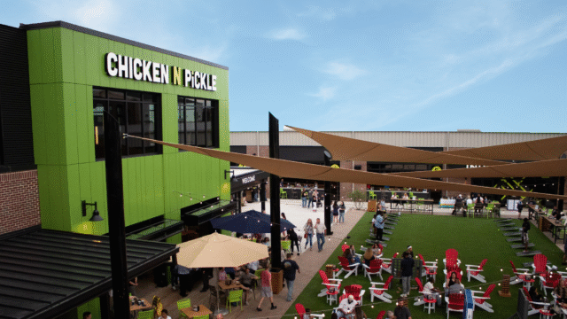 Chicken N Pickle exterior with people milling around the outdoor seating area.