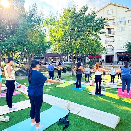 People doing pure barre exercises on The Green at Watters Creek Village