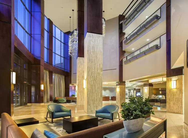 Courtyard Allen Dallas hotel lobby with modern seating, tall columns, and open atrium design.