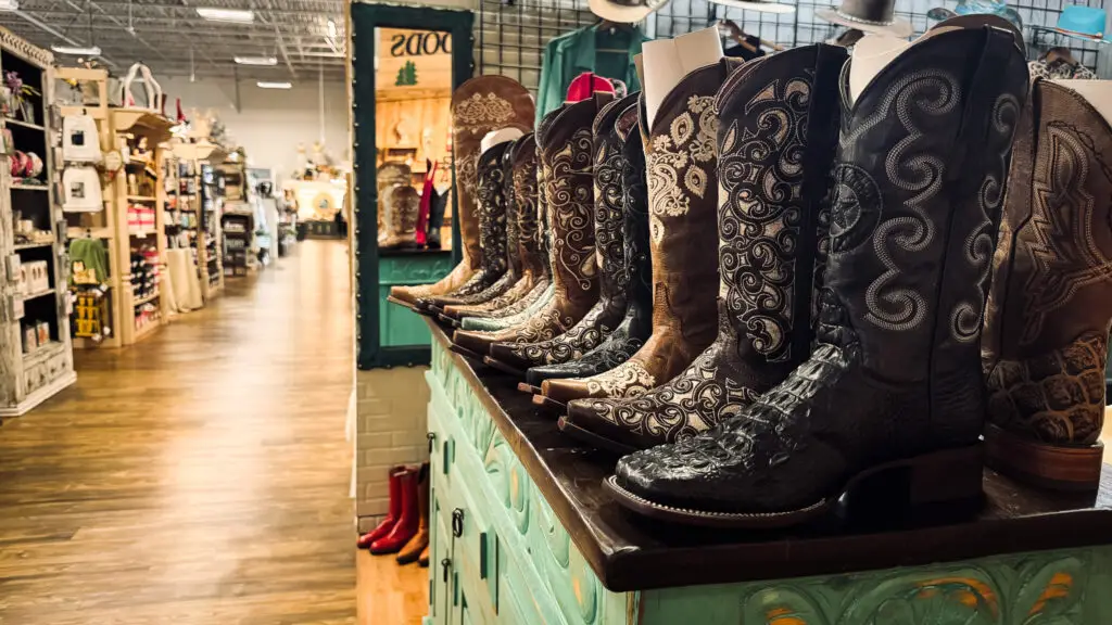 Row of intricately detailed cowboy boots on display inside Lone Star Mercantile in Allen, Texas.