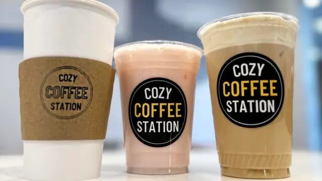 Three coffee drinks in branded cups from Cozy Coffee Station in Allen, Texas, including a hot coffee, iced latte, and blended drink.