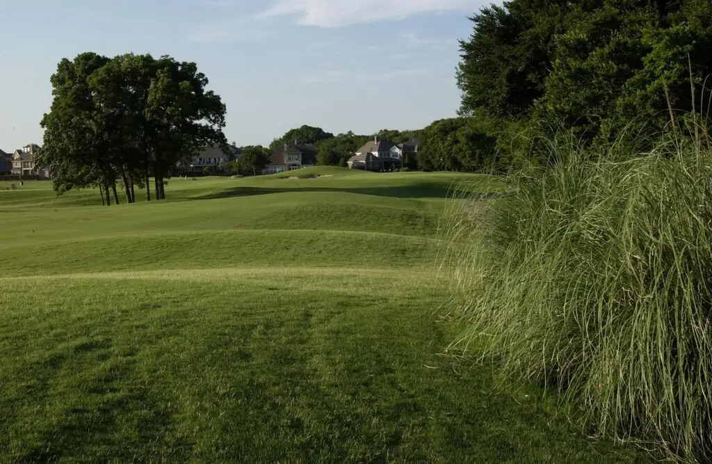 Scenic view of a fairway with trees and homes at The Golf Club at Twin Creeks in Allen, Texas.