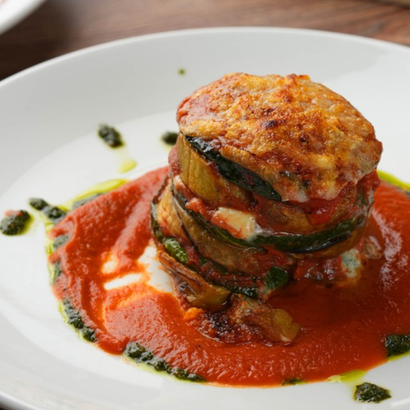 Layered Italian eggplant entrée with tomato sauce and melted cheese served at Tutto Gustoso in Watters Creek Village, Allen, Texas.