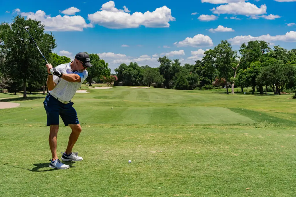 Golfer taking a swing on the course at The Courses at Watters Creek in Allen, Texas.