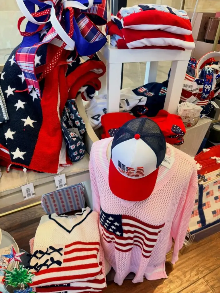 Patriotic clothing and accessories display featuring American flag sweaters, hats, and red, white, and blue décor at Hindy House.