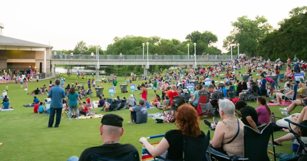 Families and visitors gathered on a grassy hillside at Bethany Lakes Park in Allen, Texas, enjoying a large outdoor community event.