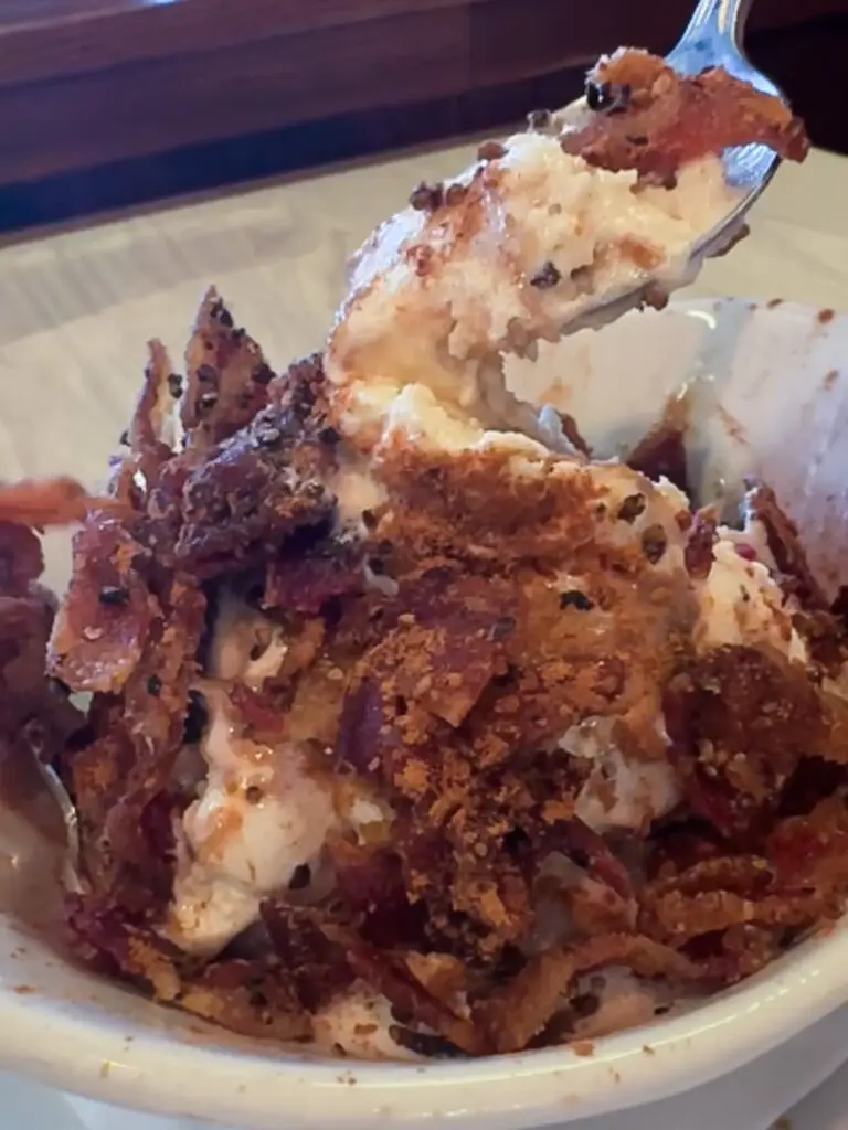 A bowl of Hog Wild Ice Cream topped with crispy bacon, cinnamon, and caramel drizzle is served at TwoRows in Allen, Texas.