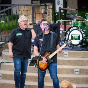 Members of The Flannel Pajamas perform on stage during Concerts by the Creek at Watters Creek Village in Allen, Texas.