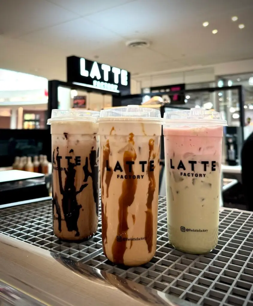 Three iced specialty drinks from Latte Factory are displayed on the counter inside the café at Allen Premium Outlets in Allen, Texas.