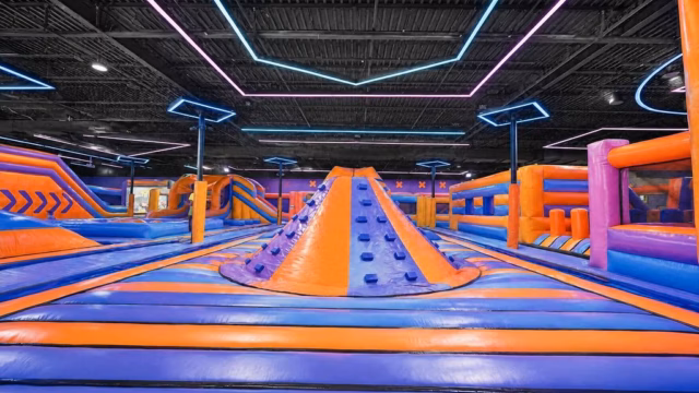 Bouncehouse with colorful material reflecting brightly from the overhead thin LED lights.