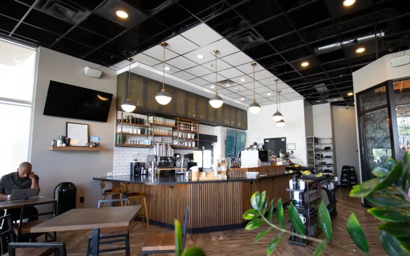 Interior of Armor Coffee with man sitting at desk and plant in bottom right corner